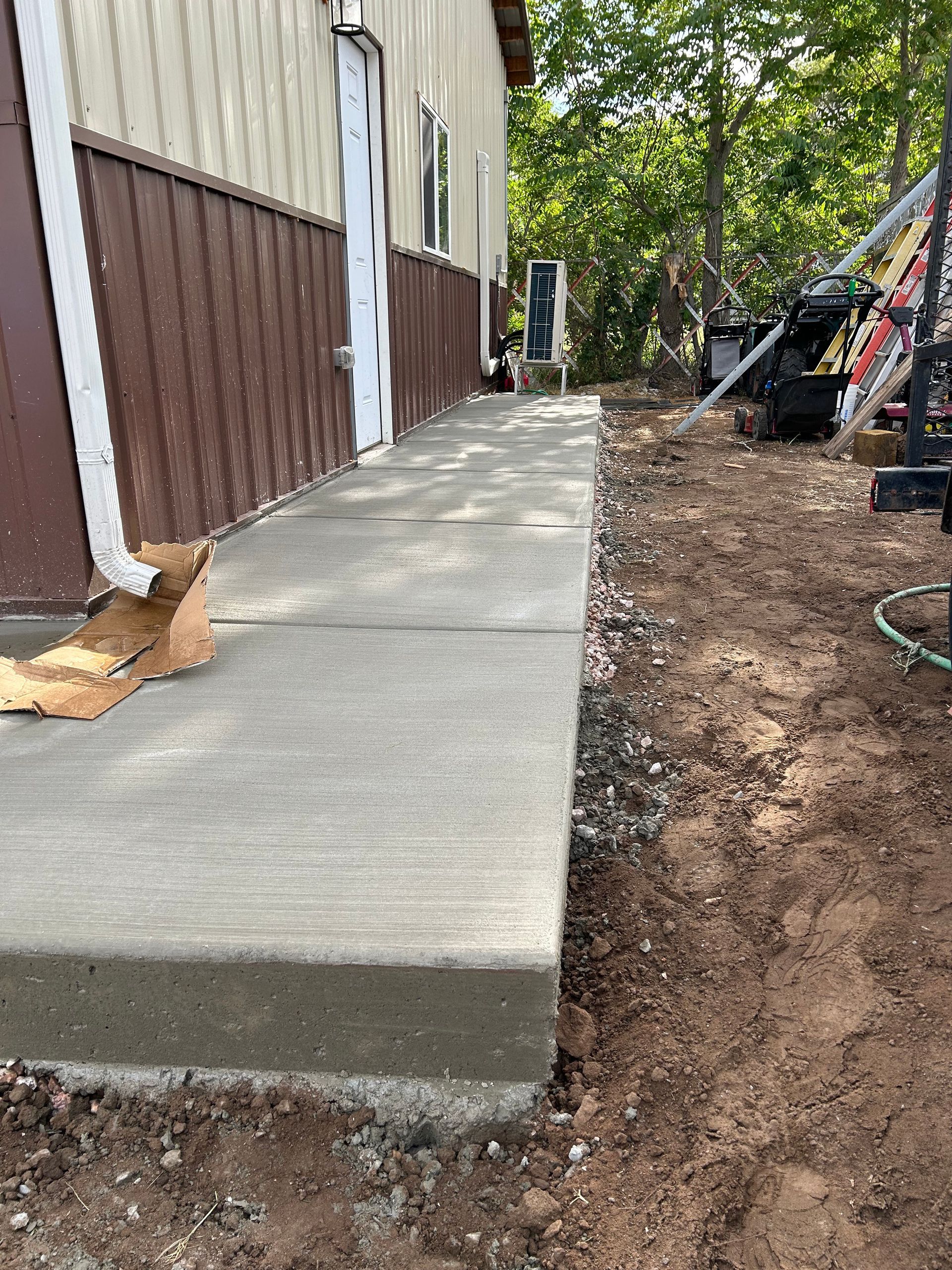 A concrete walkway is being built in front of a house.