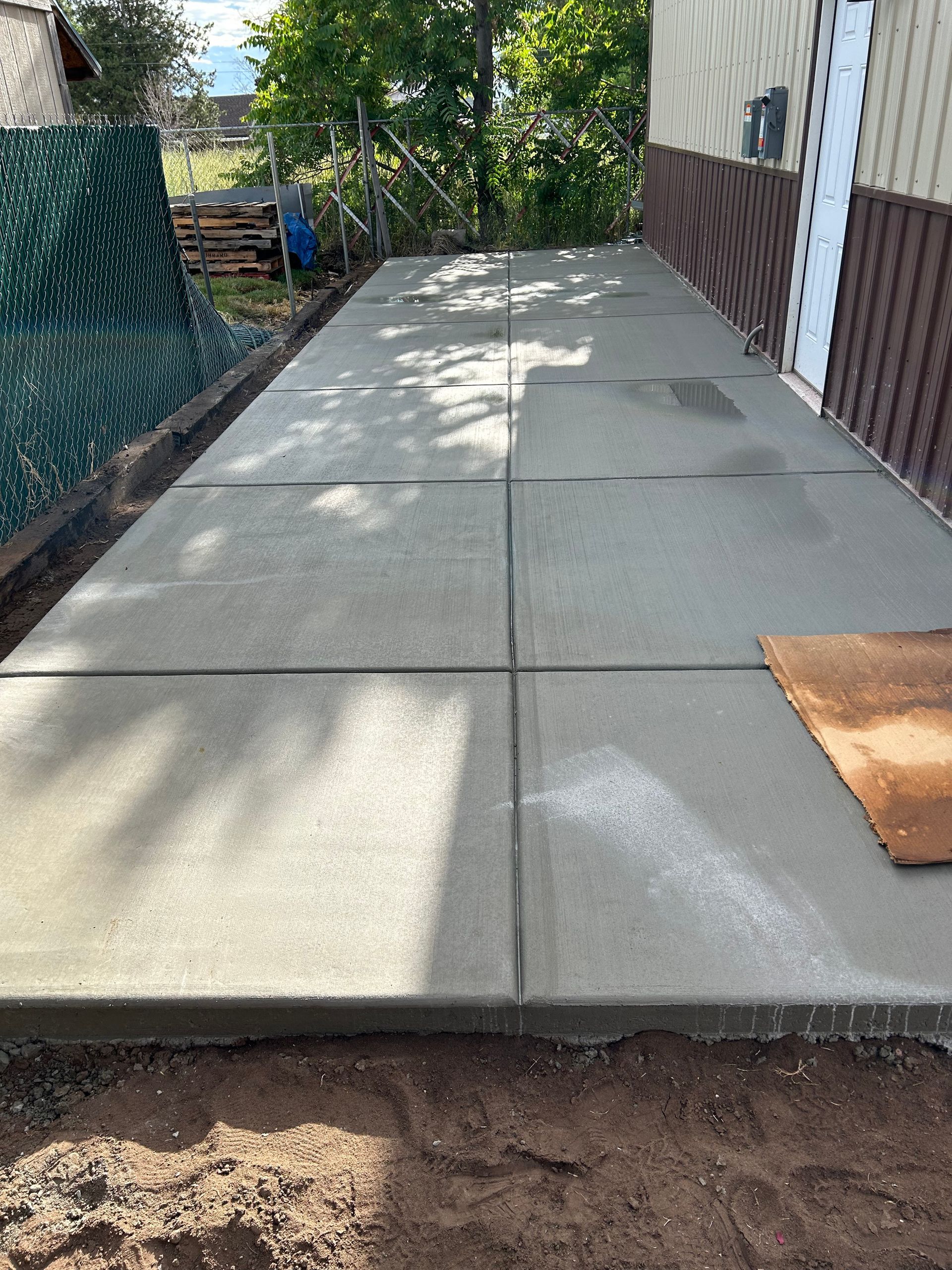 A concrete walkway is being built in front of a house.
