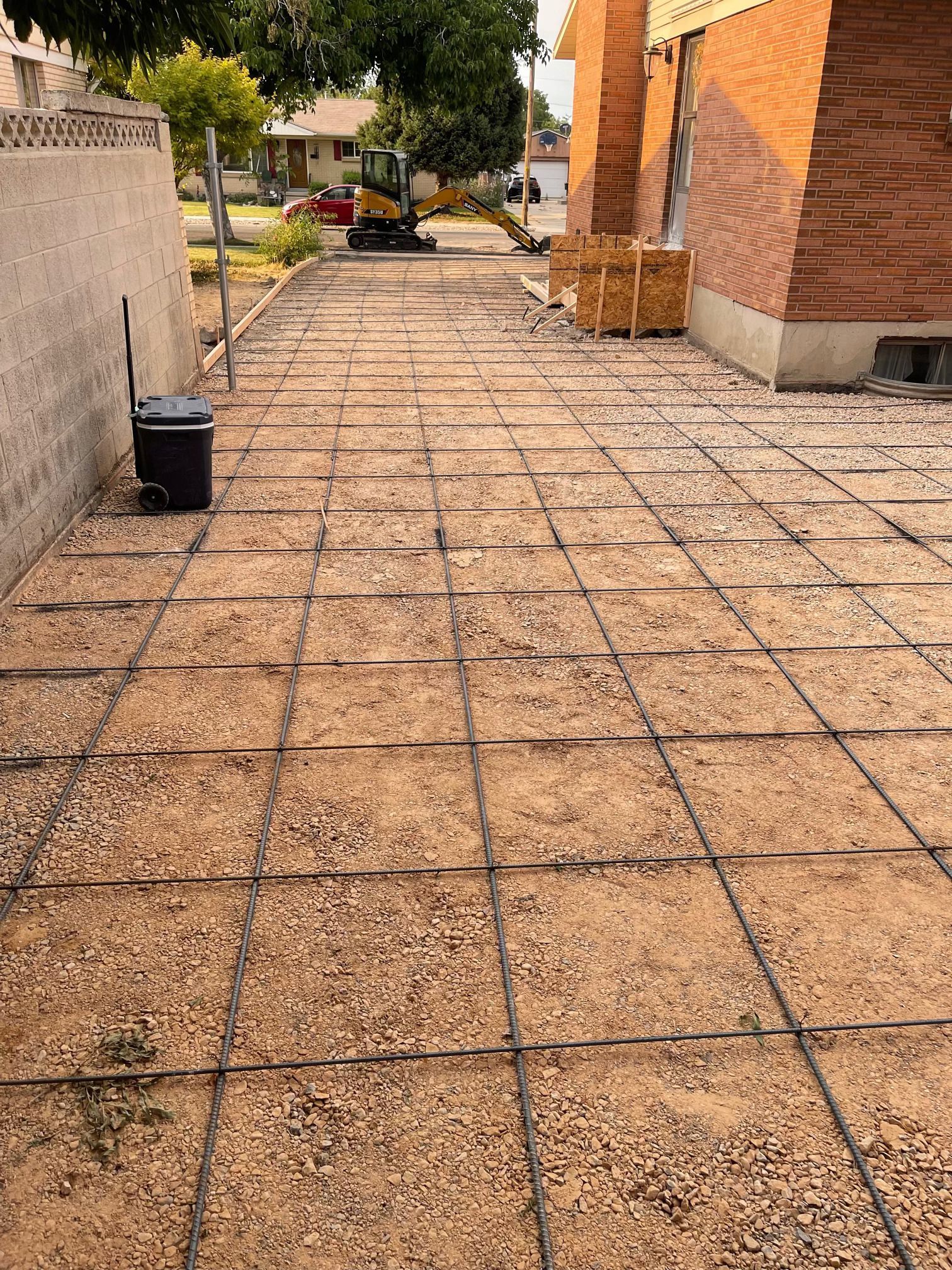 A concrete driveway is being built in front of a brick building.