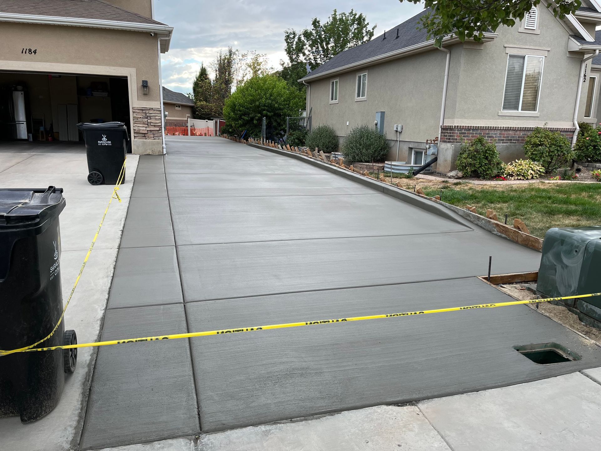 A concrete driveway is being built in front of a house.