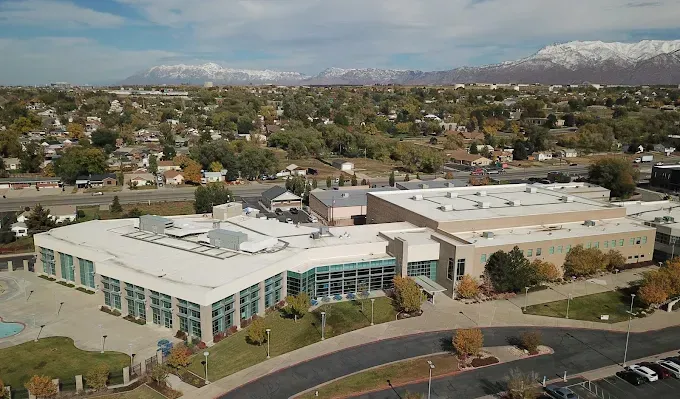 An aerial view of a large building with mountains in the background.
