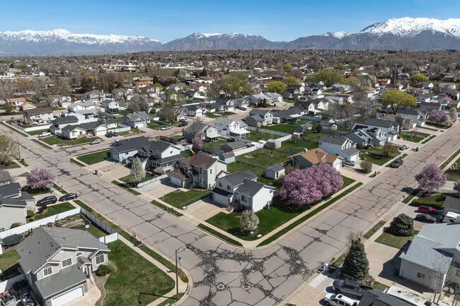 An aerial view of a residential neighborhood with mountains in the background.