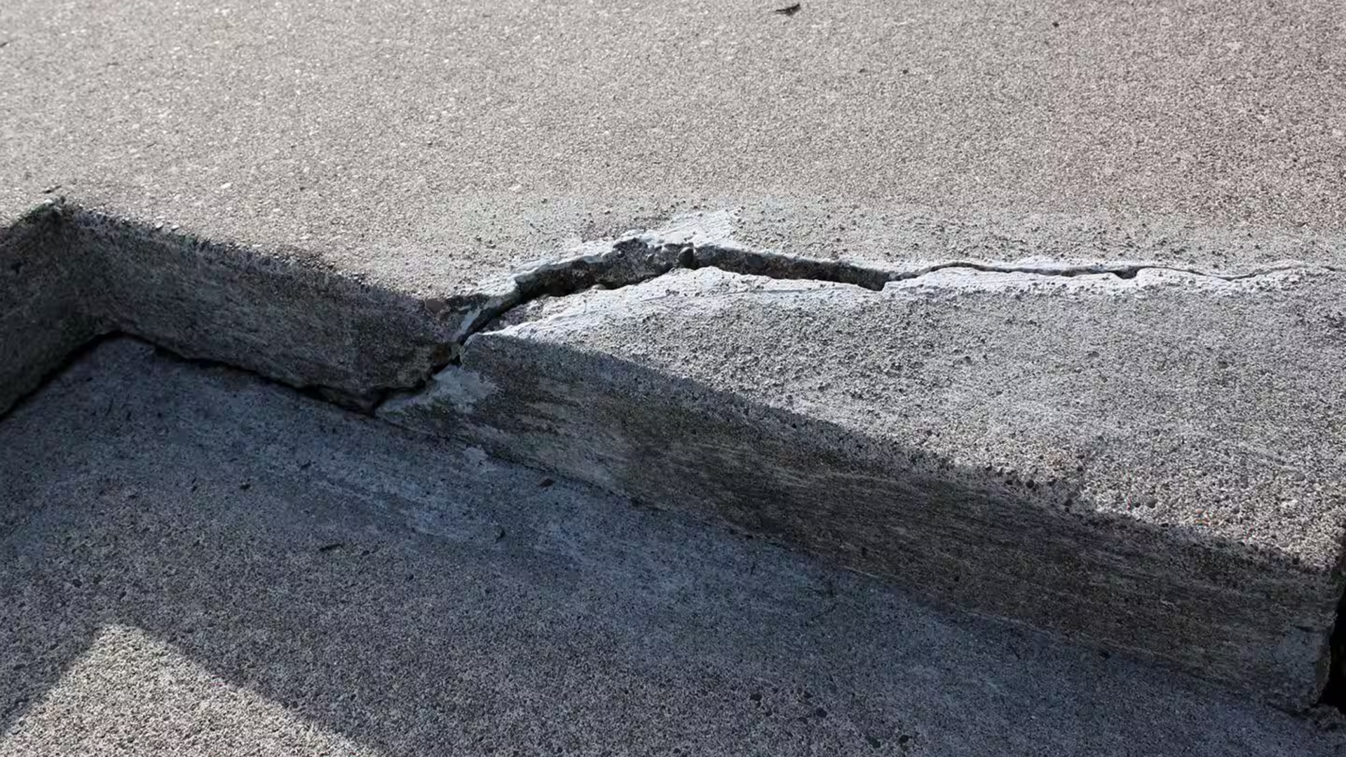 Concrete driveway edge cracking and chipping from load stress and erosion