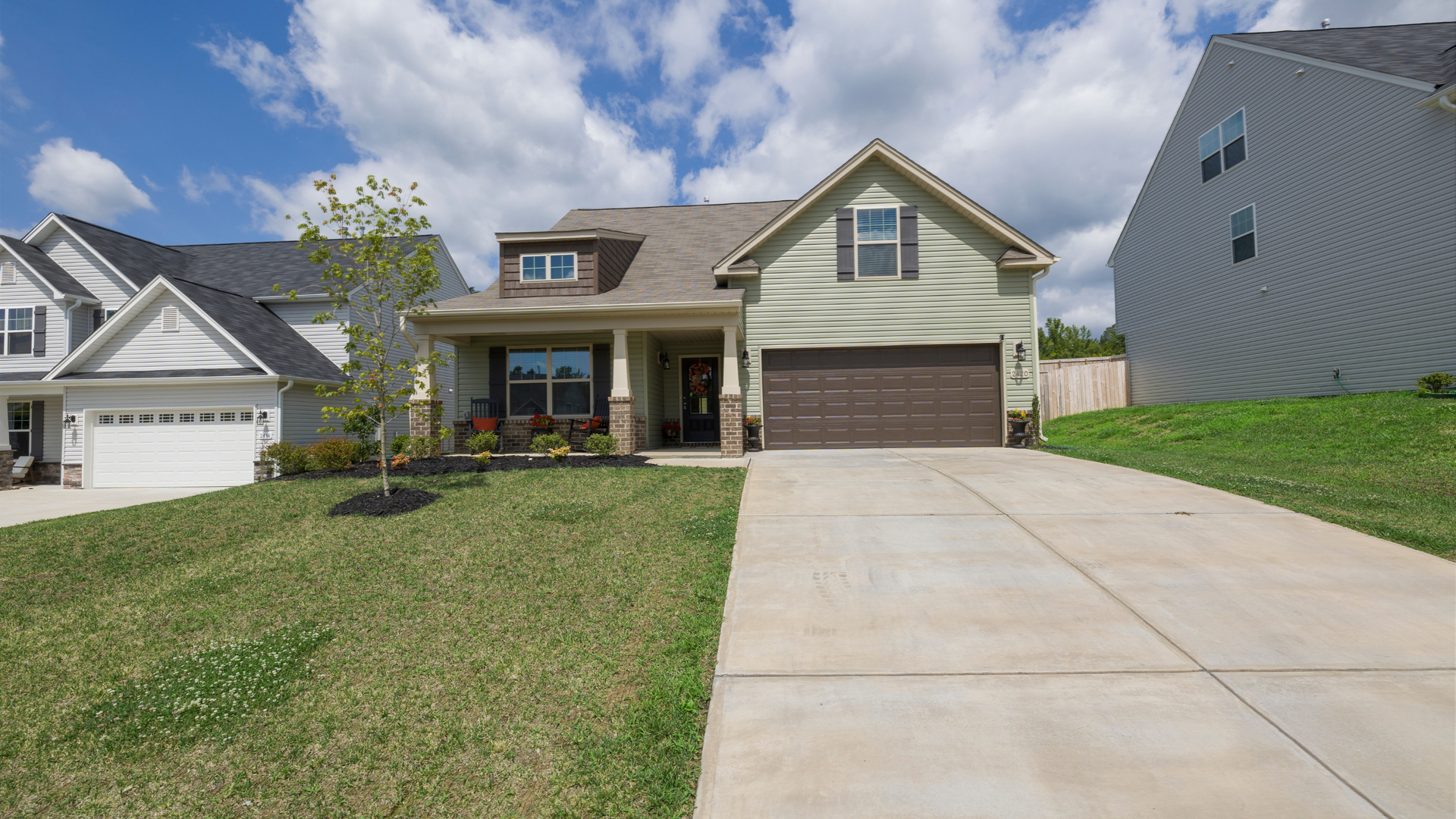 Concrete driveways in Syracuse Utah with a smooth modern finish in front of a residential home