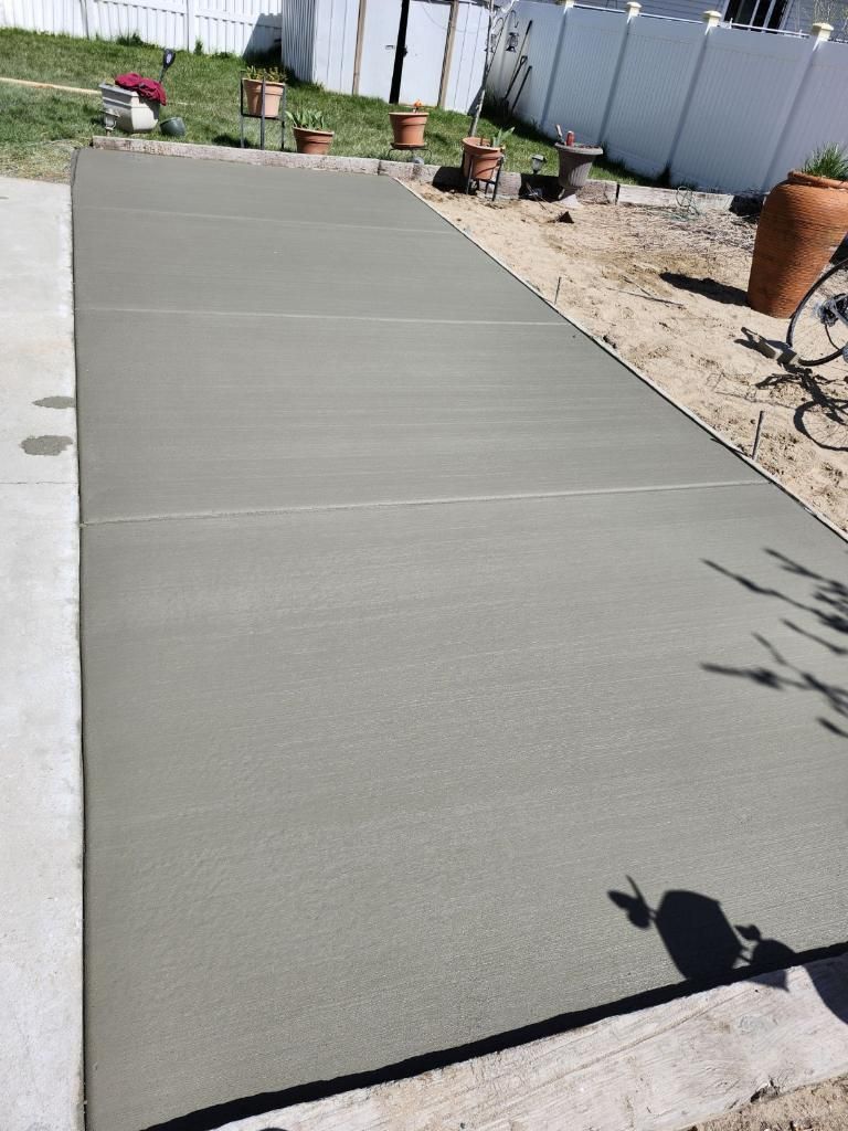 A concrete driveway is being built in a backyard.