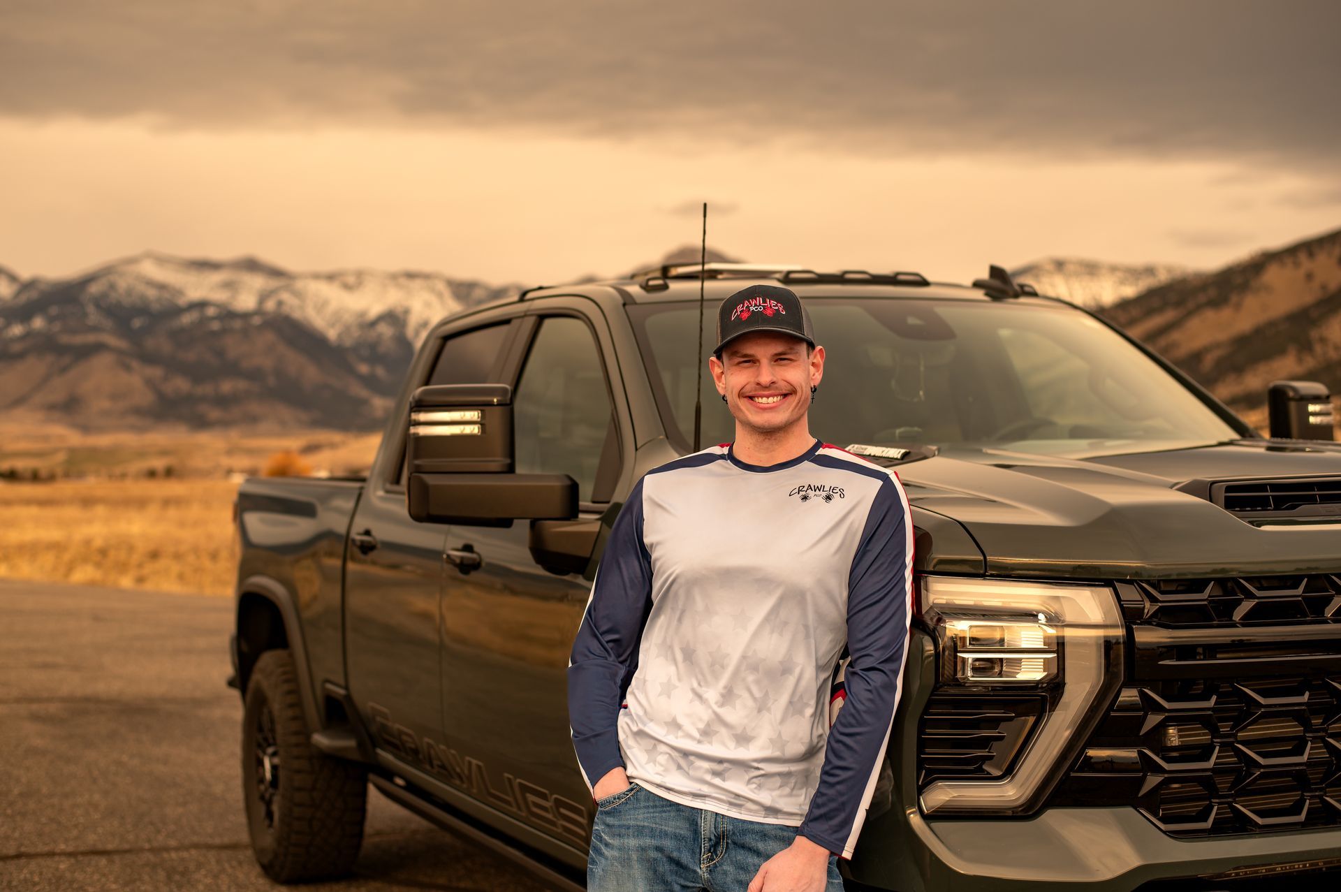 Hand holding magnifying glass over bed with bed bugs.