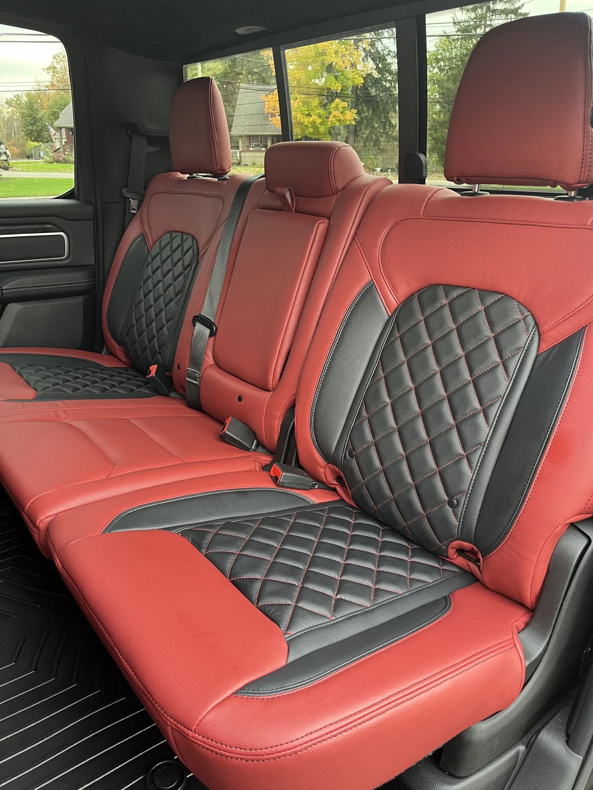 The back seat of a truck with red and black seats