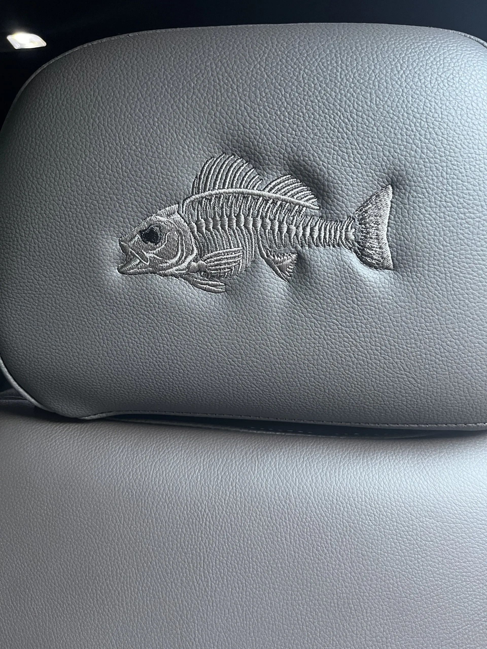 A close up of a headrest with a fish embroidered on it