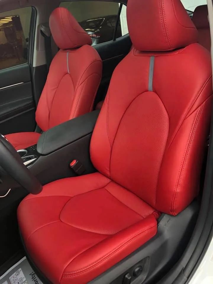 A white car with red seats and a steering wheel