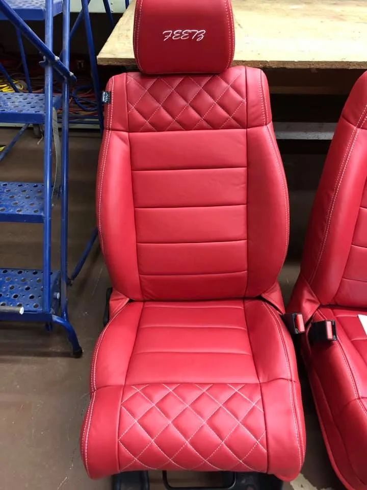 A pair of red leather seats are sitting next to each other on a table