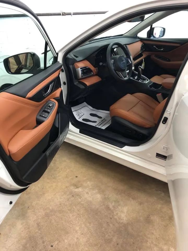 The interior of a white car with brown leather seats and a steering wheel