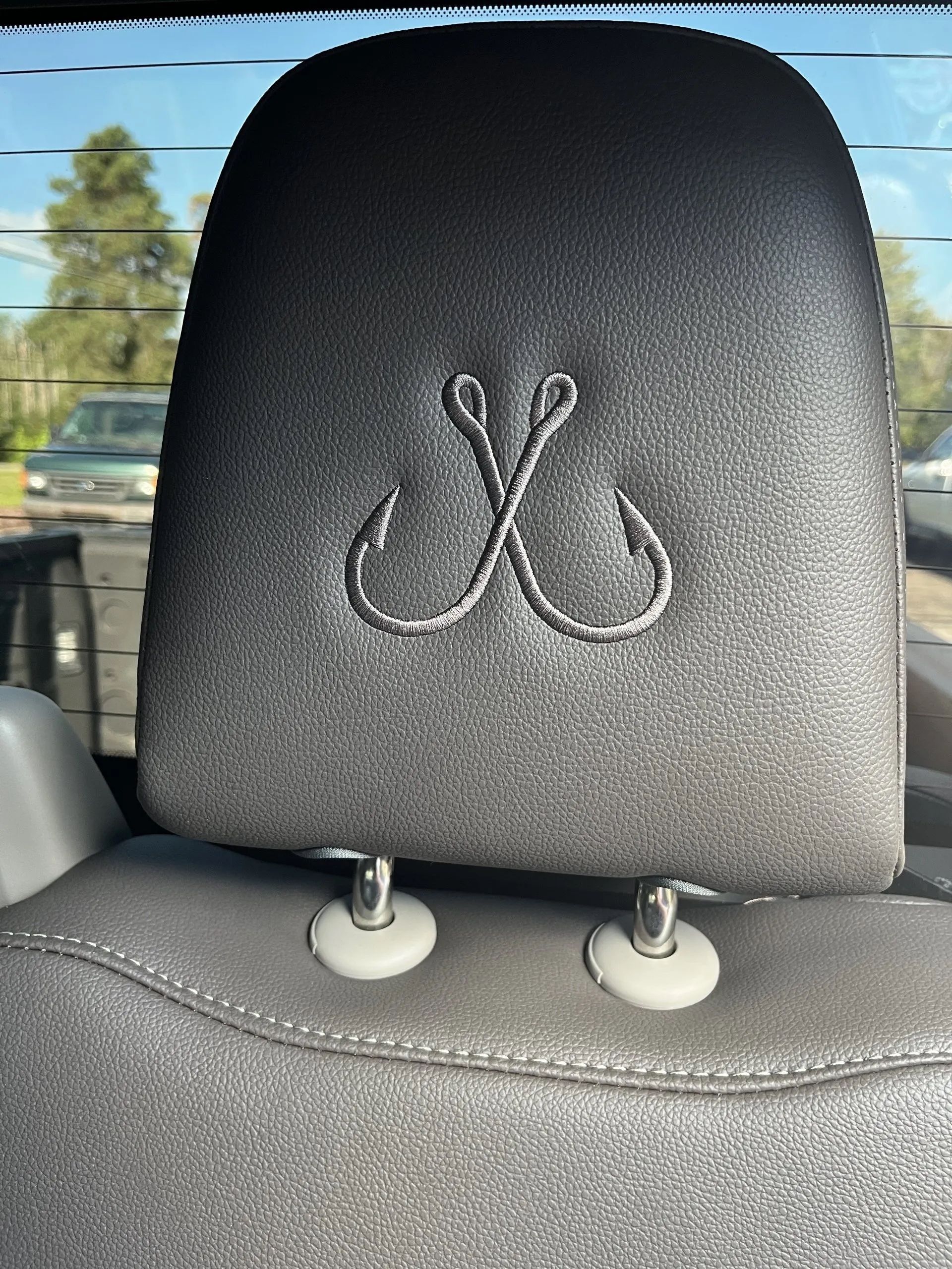 A car headrest with a fishing hook embroidered on it