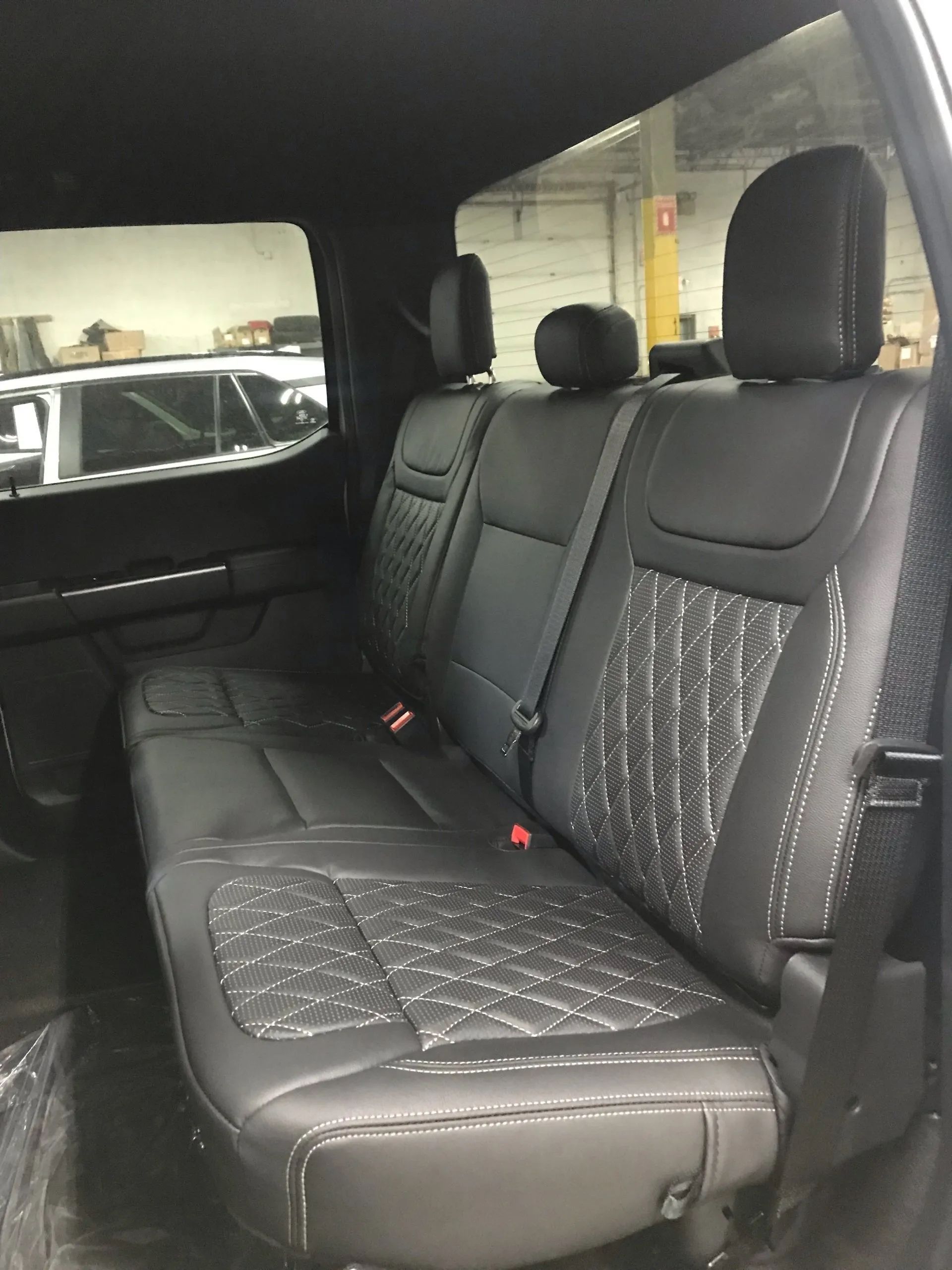 The back seat of a truck with black leather seats