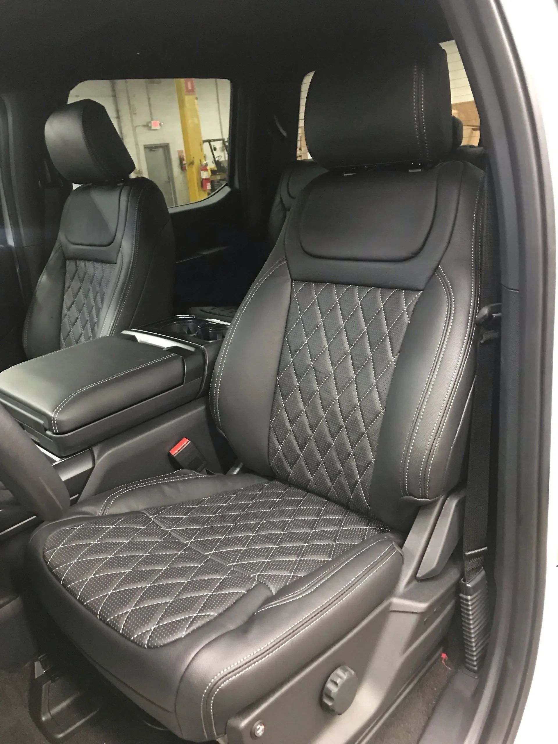 A white truck with black leather seats and a center console