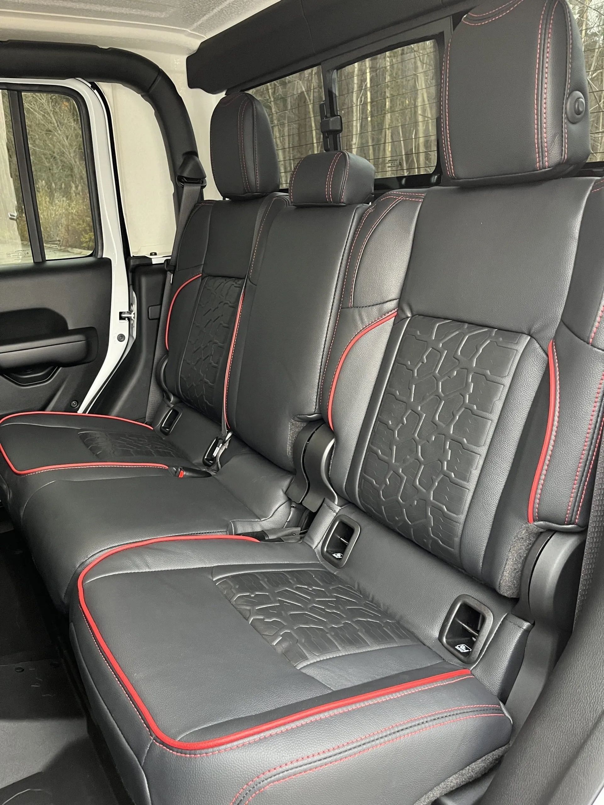 The back seats of a jeep wrangler are black and red
