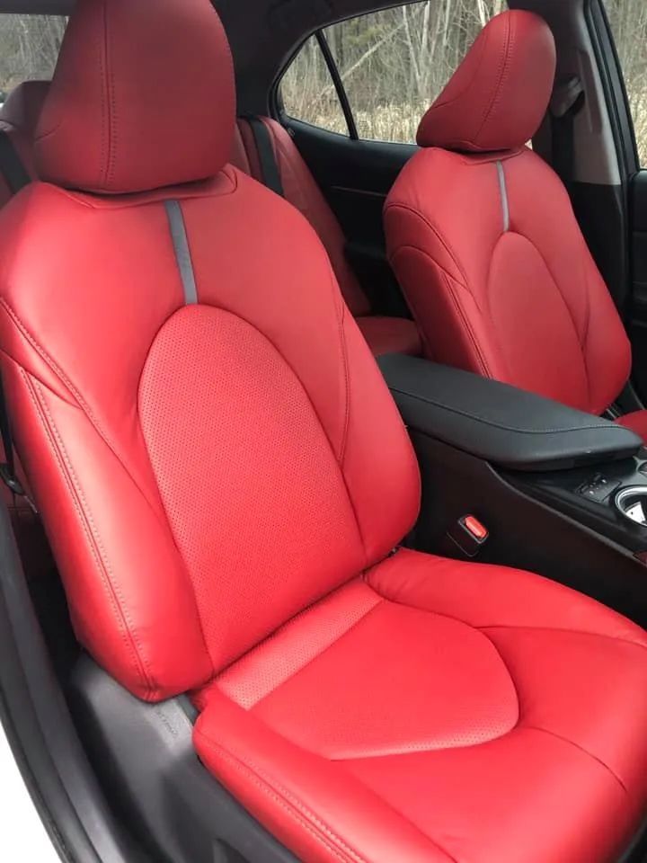 A white car with red seats and a black console