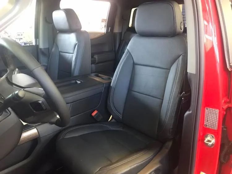 A red truck with black leather seats and a steering wheel