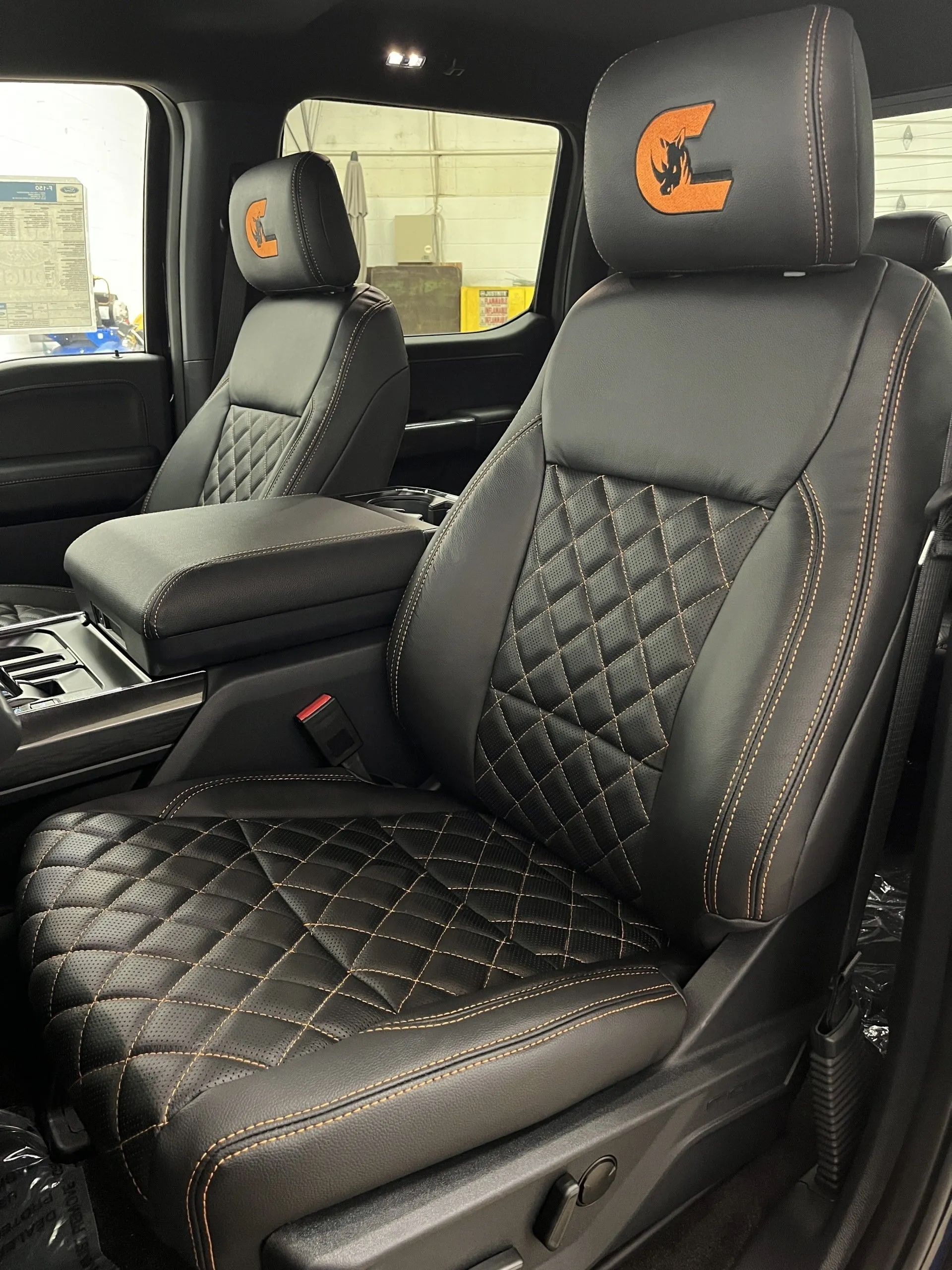 A close up of a car seat with a horseshoe on the headrest