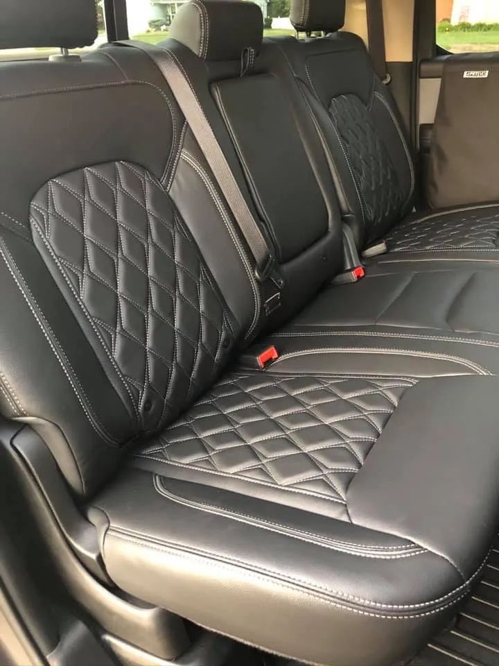 The back seat of a car with black leather seat covers