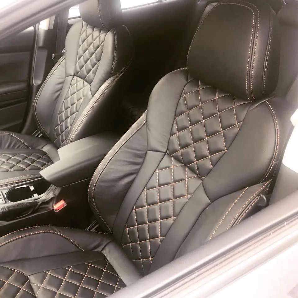 A pair of black leather seats in a car