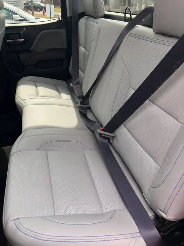 The back seat of a car with seat belts on it