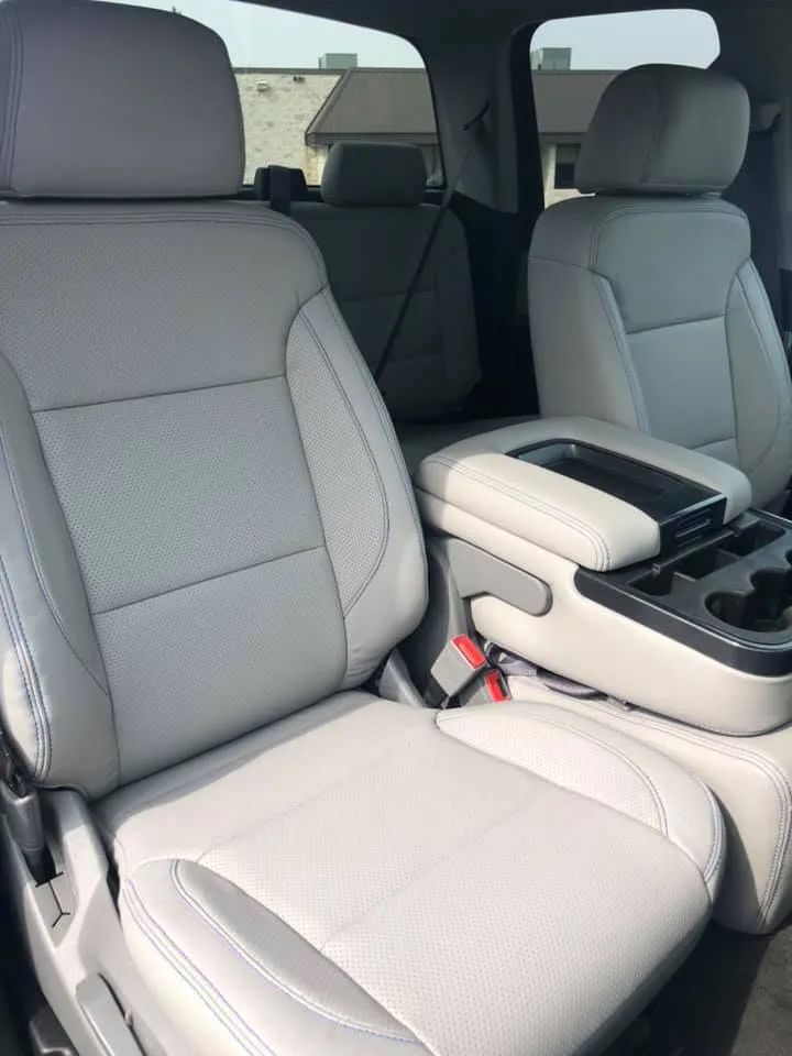 The interior of a car with white leather seats and a center console