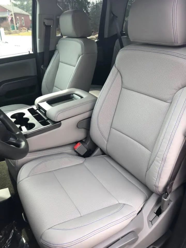 The interior of a car with white leather seats and a steering wheel
