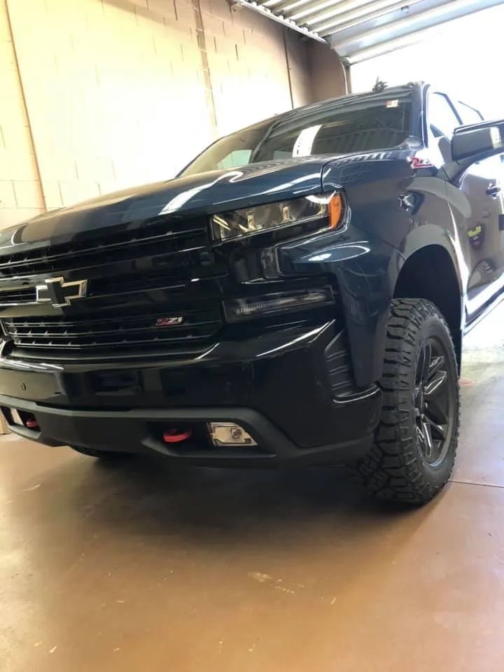 A black chevrolet silverado 1500 is parked in a garage