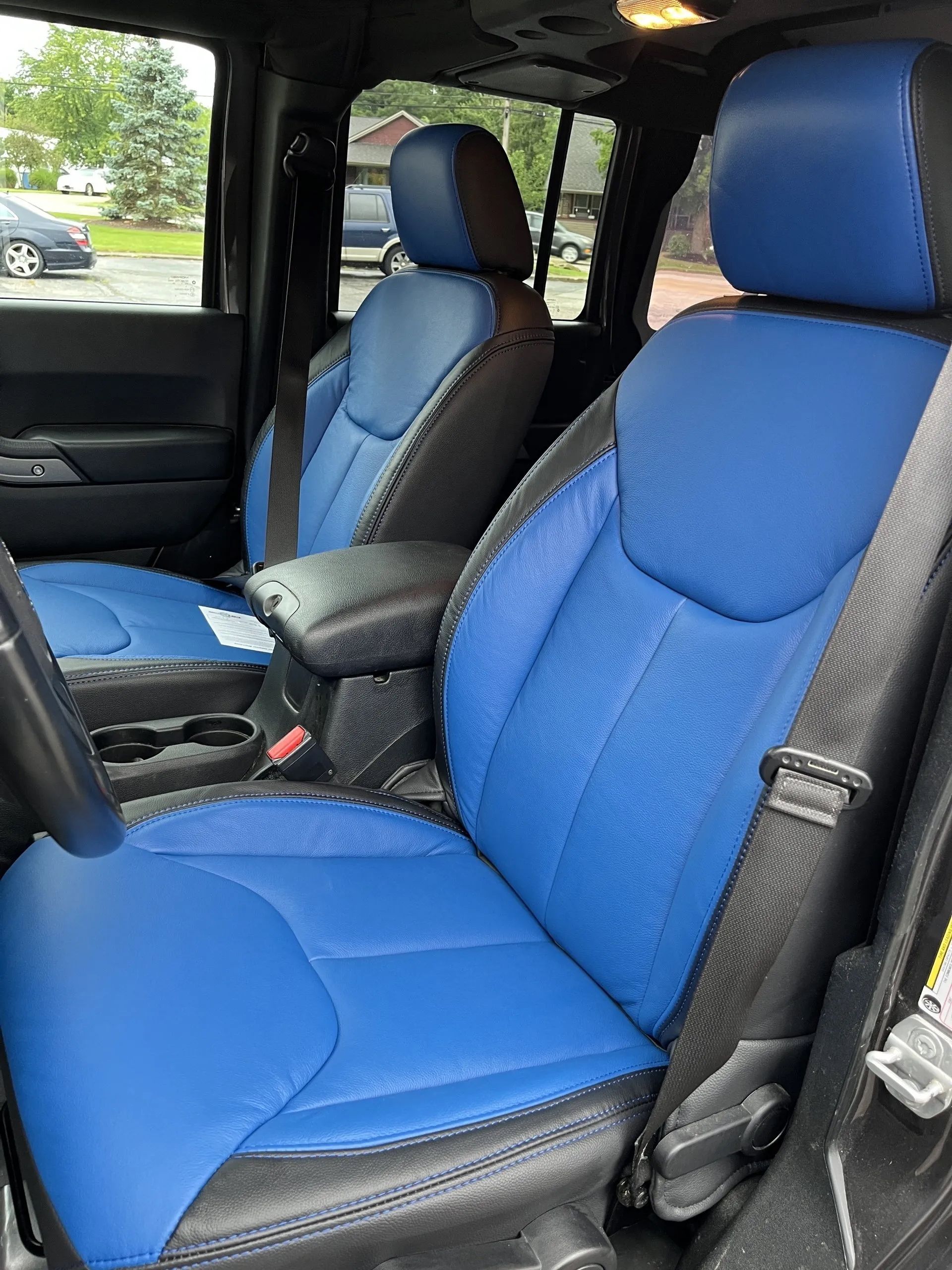 The front seats of a jeep wrangler are blue and black