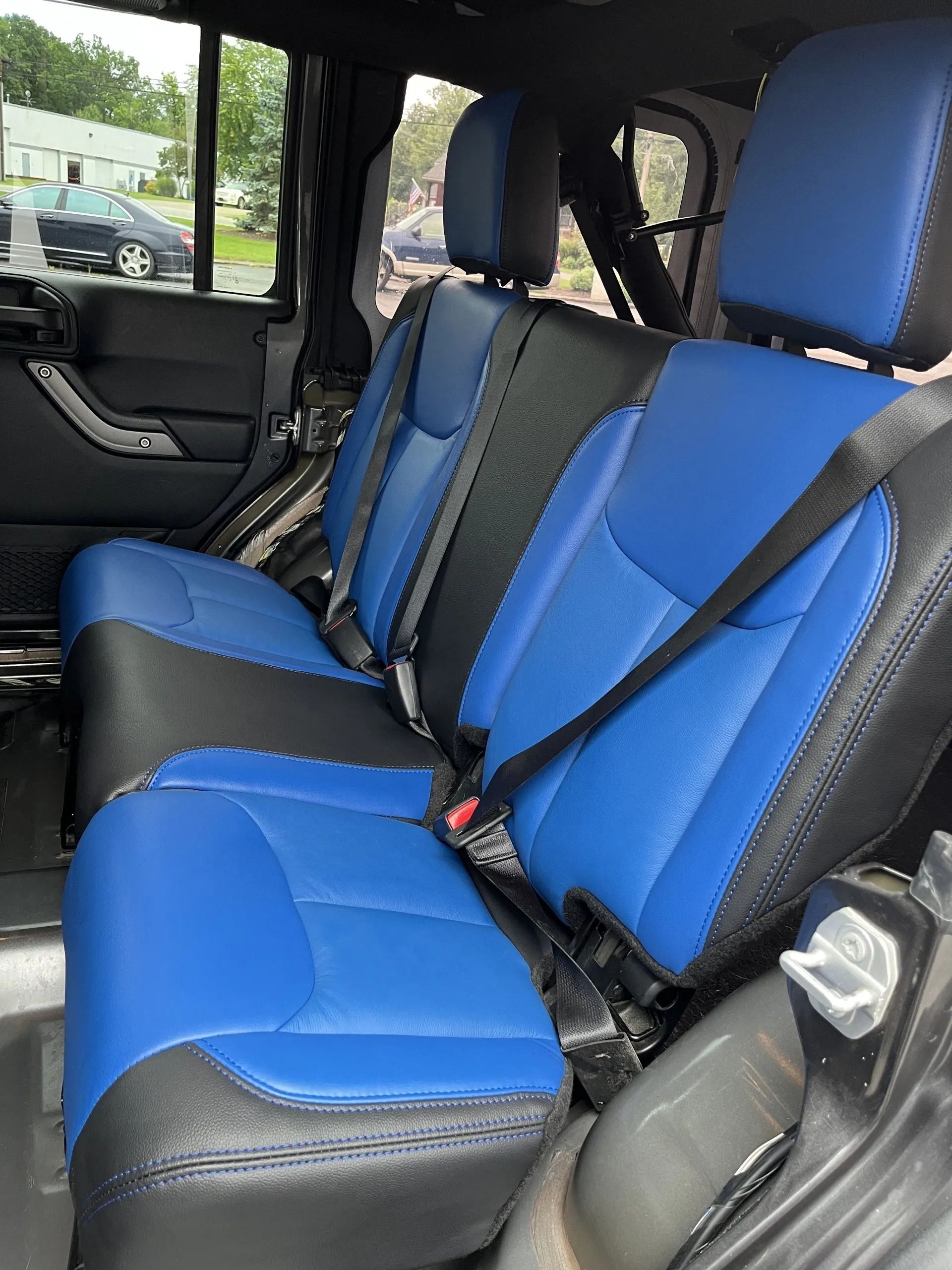 The back seats of a jeep are blue and black