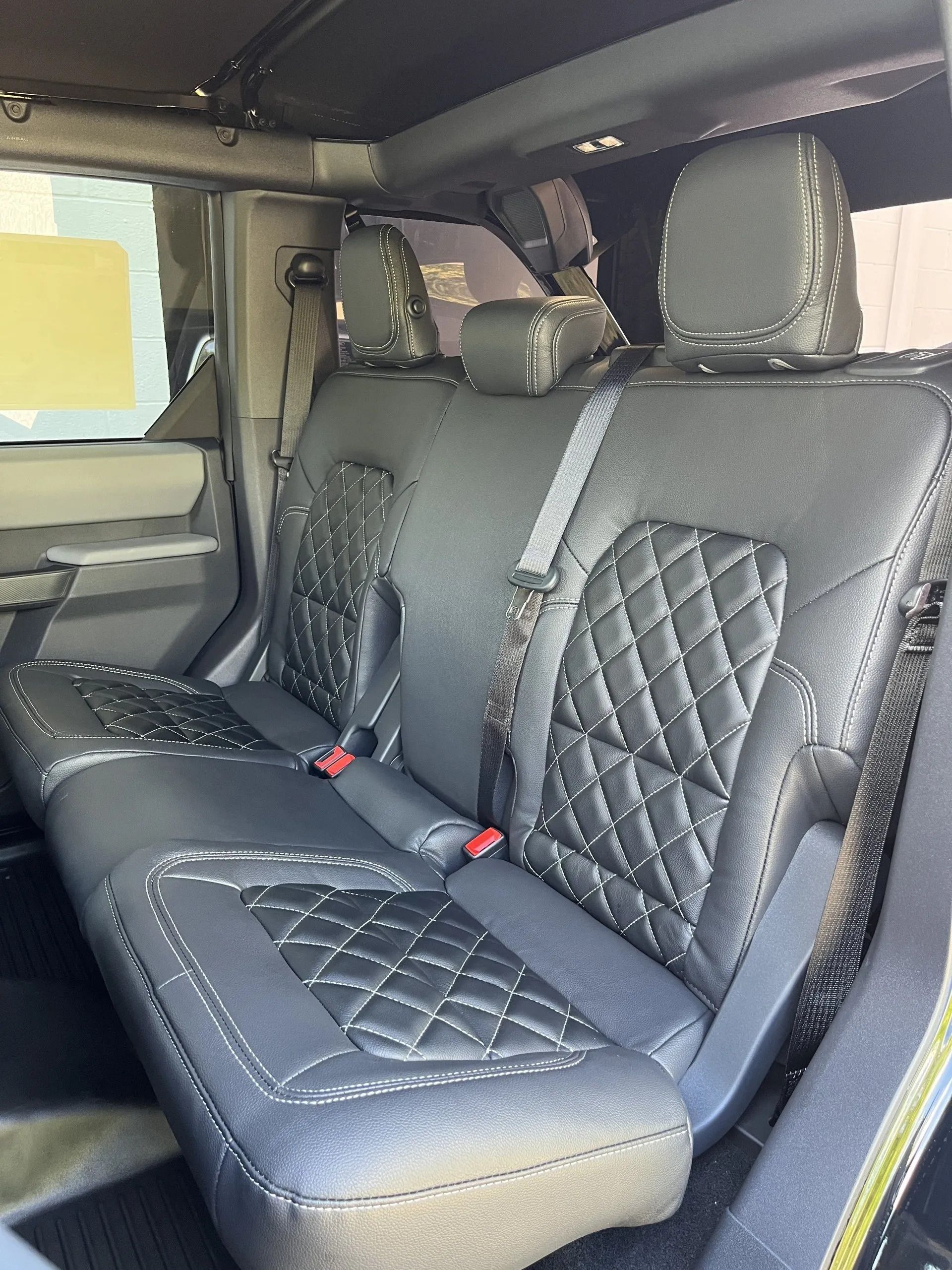The back seat of a jeep wrangler with black leather seats