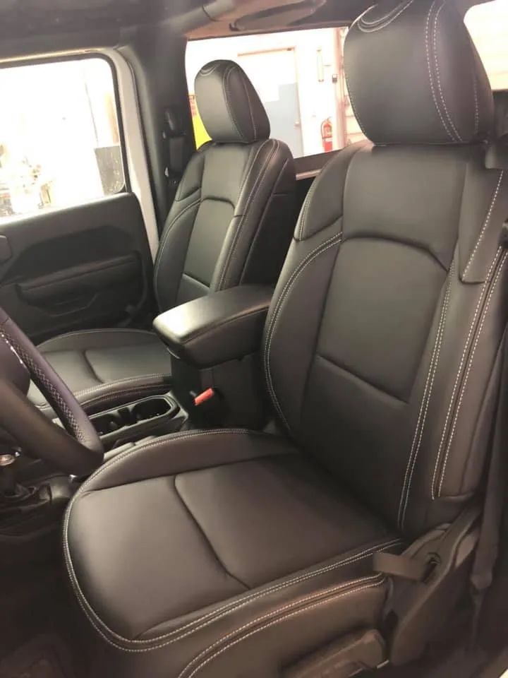 The interior of a jeep wrangler with black leather seats