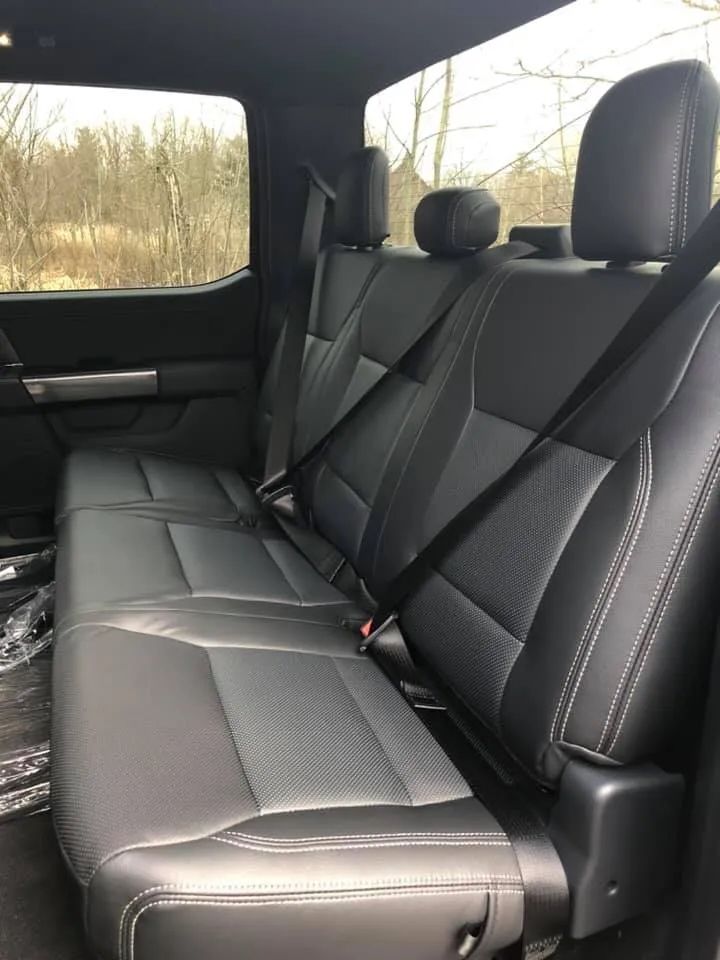 The back seat of a truck with seat belts on it