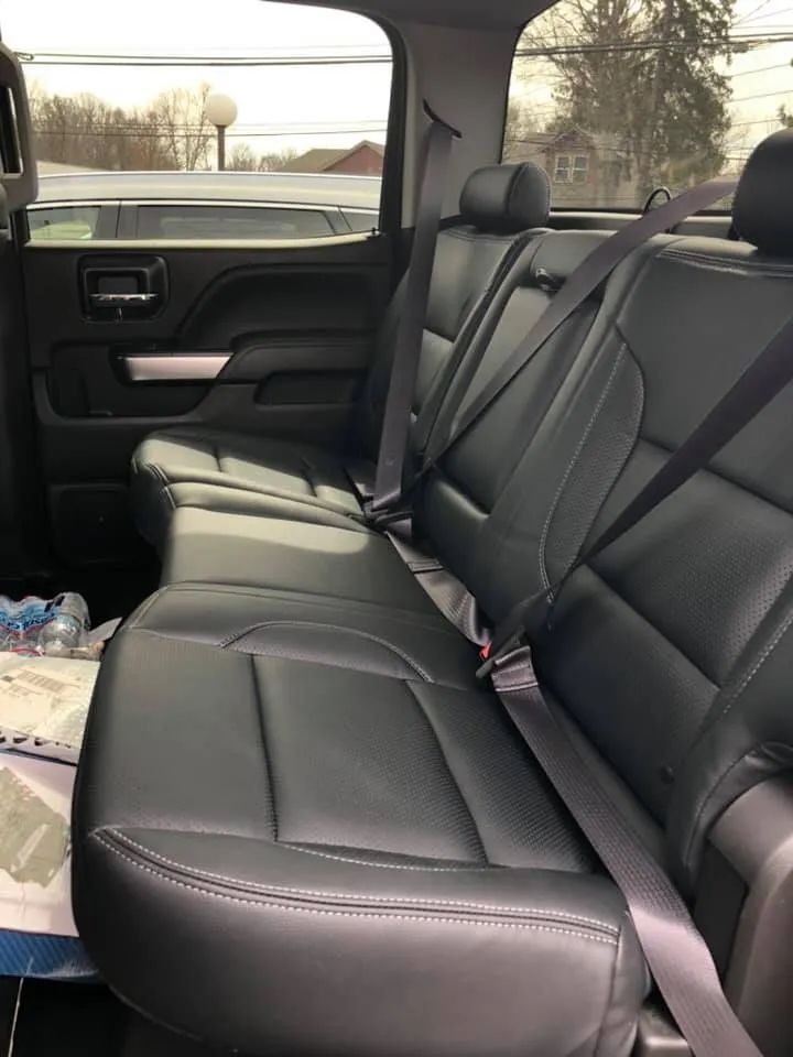 The back seat of a truck with seat belts on it