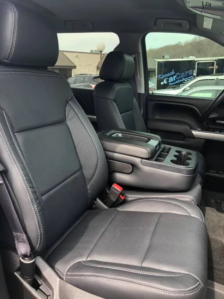The interior of a truck with black leather seats and a center console