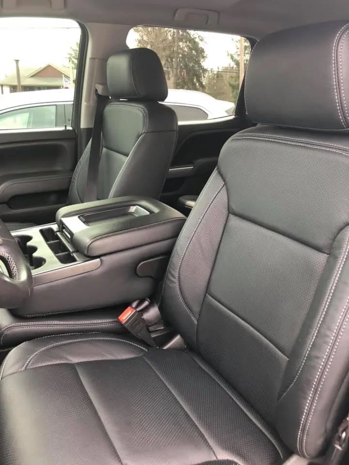 The inside of a car with black leather seats and a center console