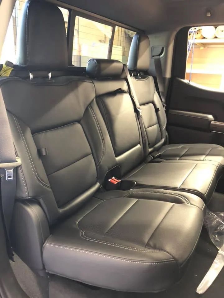 The back seat of a truck with black leather seats