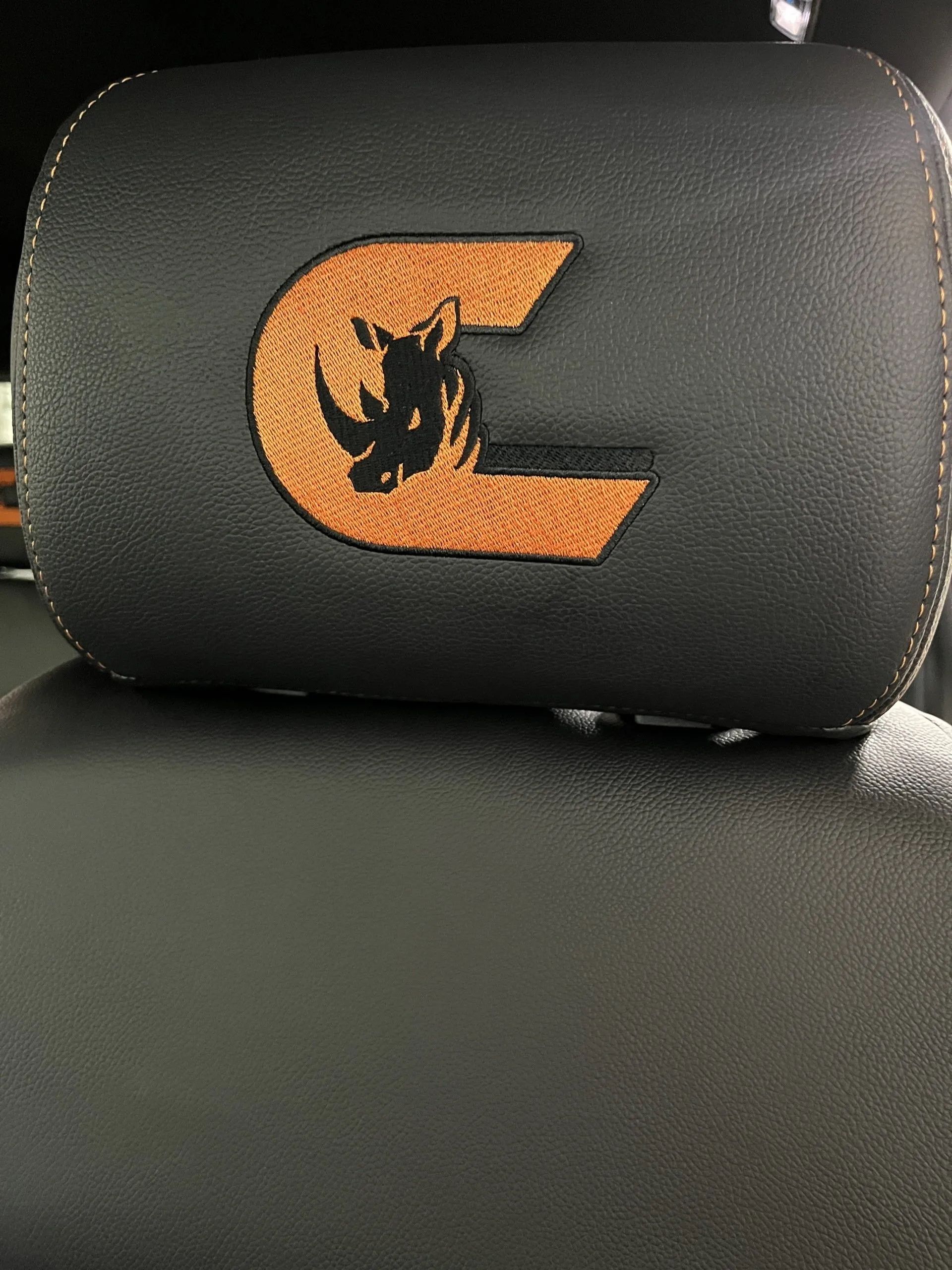 A headrest with a rhinoceros embroidered on it