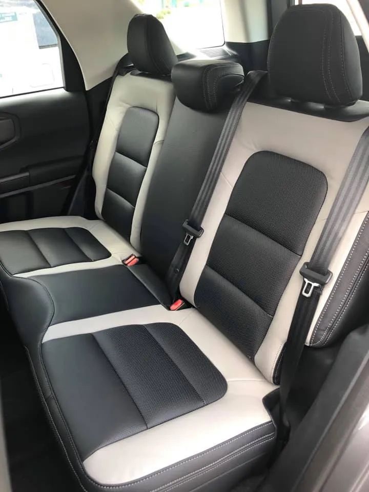 The back seat of a car with black and white seats