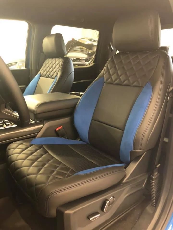 The front seats of a ford f150 raptor are black and blue
