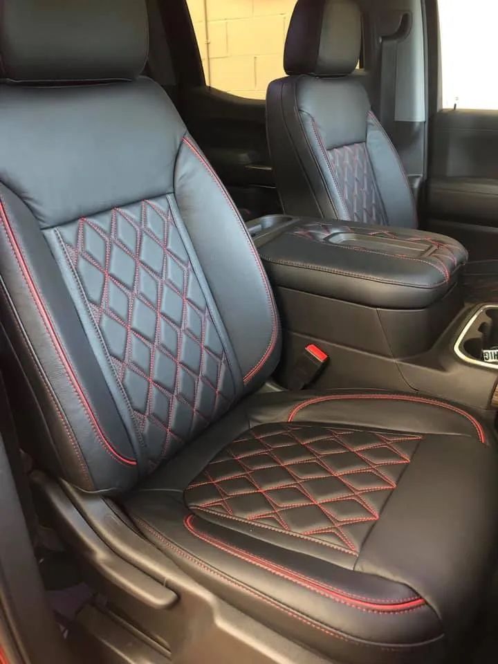 A close up of a car seat with a red stitching