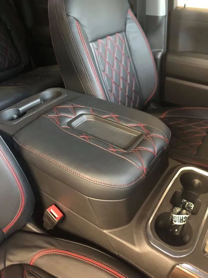 A car with black leather seats and a red stitching on the arm rest