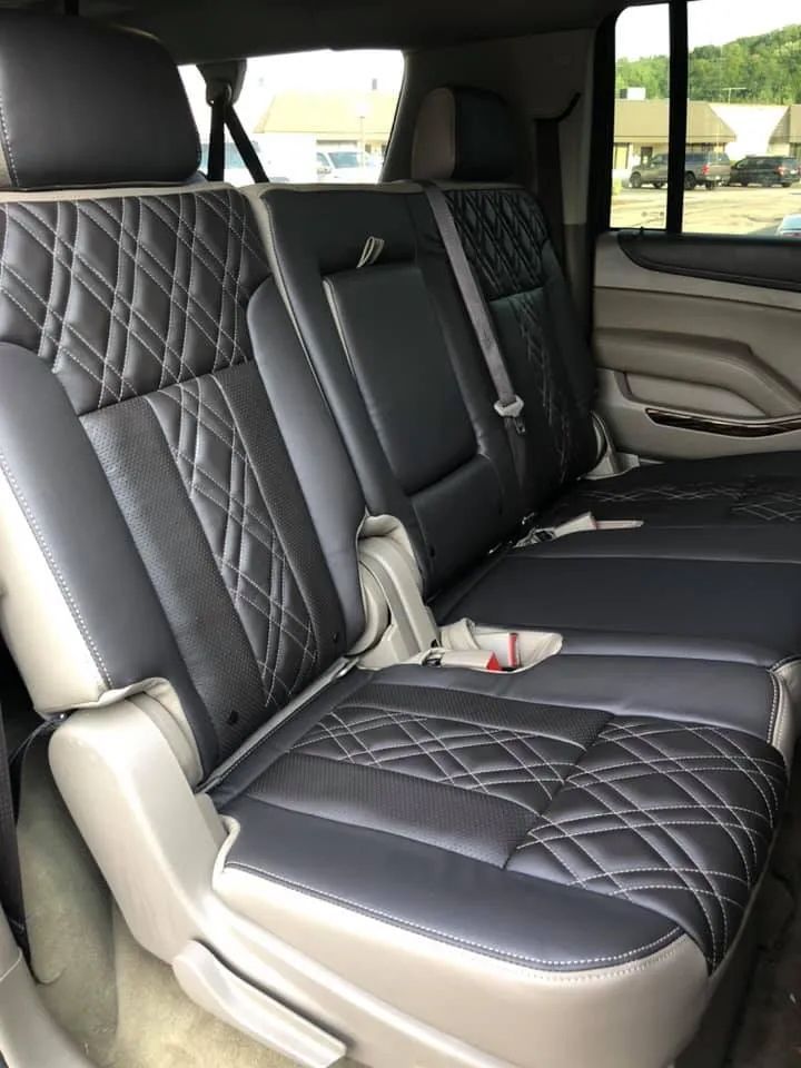 The back seat of a car with black leather seat covers
