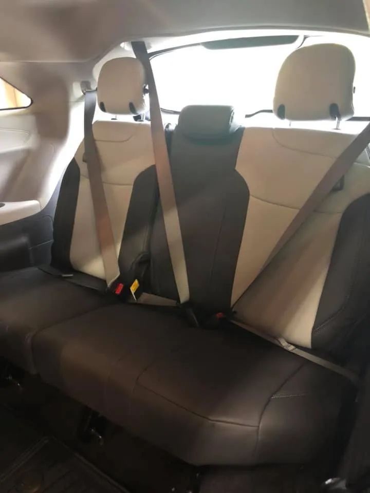 The back seat of a car with seat belts on it
