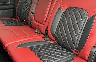The back seat of a car with red and black seats