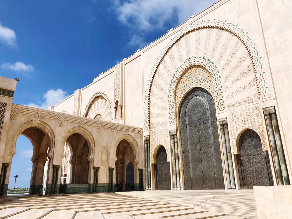 Un gran edificio con arcos y una gran puerta en un día soleado.