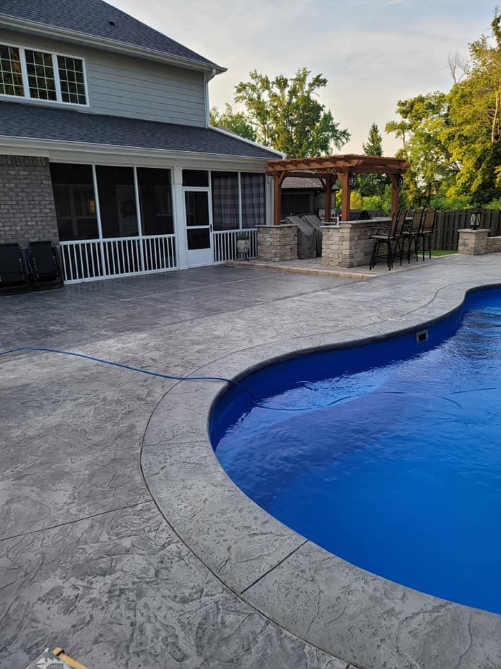 Backyard pool beside a screened patio and pergola on a concrete deck