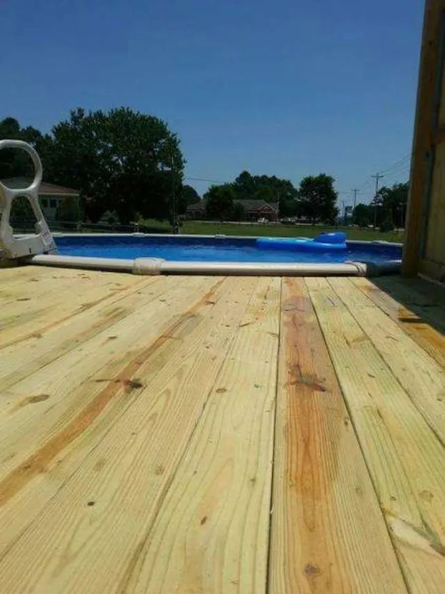 Wooden deck beside an above-ground pool on a sunny day