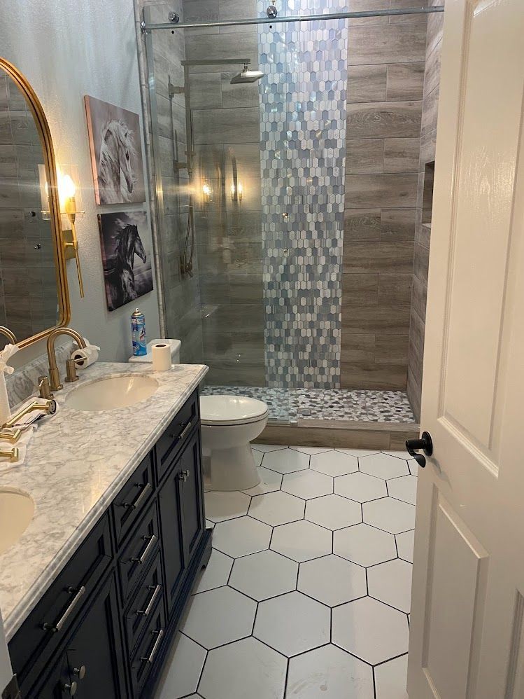 A bathroom with a sink , toilet , shower and mirror.