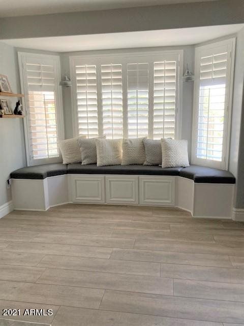 A living room with a couch and shutters on the windows.